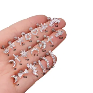 Detailansicht von Edelstahl-Piercing-Schmuck mit Zirkonia-Formen wie Kreuz und Schleife.