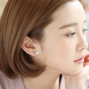 Detailed shot of Korean style flower cartilage earring studs with sparkling stones for women.