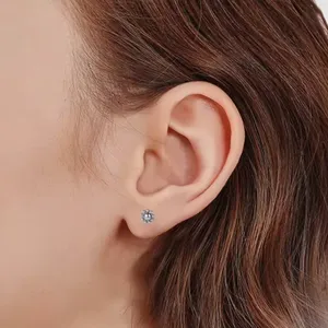 Gedetailleerde opname van titanium piercing sieraden met een fijn kogelbloem ontwerp.