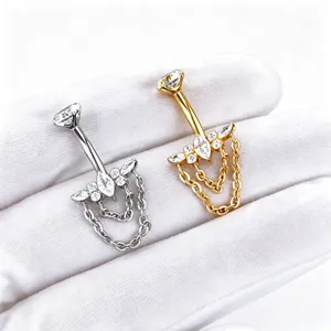 Titanium navel ring detail featuring sparkling cubic zirconia butterfly and hanging chains.