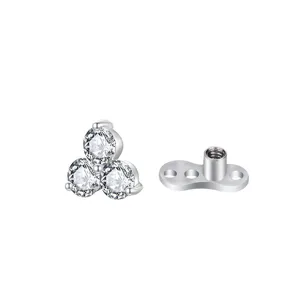 Dettaglio top microdermal in acciaio con tre pietre di zircone a grappolo dettaglio.