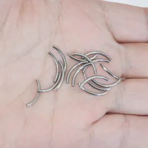 Close-up detail view of curved titanium body piercing bars and replacement rods, smooth finish.