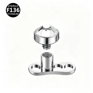 Titanium dermal anchor piercing top with clear crystal gemstone, detailed close-up view.