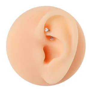 F136 alloy curved barbell eyebrow piercing with sparkling cubic zirconia stones. Detail view.