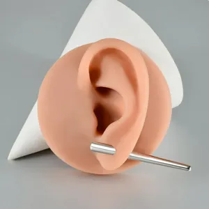 Detailed close-up of 316L stainless steel body piercing stretching taper tool on ear model.
