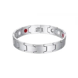 Detailweergave van zilveren magnetische armband met rode en witte bio-magnetische inzetstukken