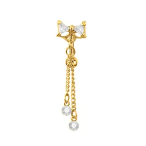 Detalle de piercing de ombligo dorado con lazo de cristal brillante y cadenas colgantes.