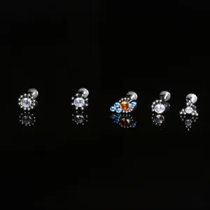 Primo piano dettagli di gioielli per piercing in titanio, zirconi scintillanti, set multiplo.