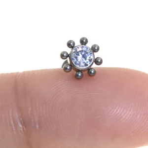 Primo piano dettagliato di gioielli per piercing in titanio con zircone e design a grappolo di sfere.