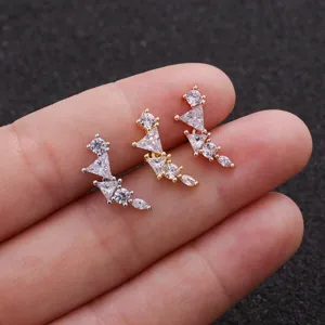 Gros plan détaillé de boucles d'oreilles incurvées en zircone aux trois coloris métalliques.