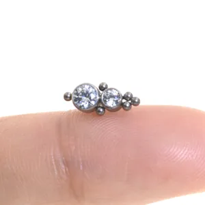 Gioiello per piercing in titanio con doppia zirconia e delicate palline saldate e fini.