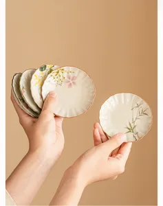 Handbemalte Keramik Blumenblüten Tee Untertasse Untersetzer Detailansicht mit Teezubehör.