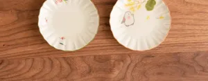 Nahaufnahme handbemalter Keramik-Teeuntersetzer mit süßem Hasen- und Blumenmuster.