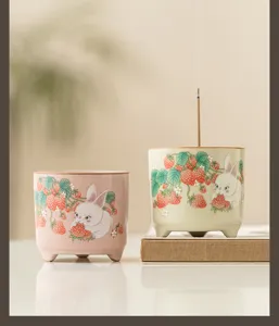 Primo piano dettaglio del bruciatore di incenso in ceramica con coniglio e fragola.