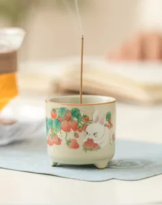 Dettaglio in primo piano del bruciatore di incenso in ceramica con coniglio e fragola.