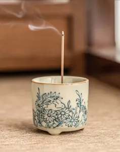 Ceramic incense burner holder detail featuring a cute rabbit and daisy flower pattern with smoke.