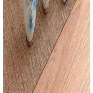 Close-up detail of blue and white ceramic tea set base resting on woven mat and wooden table.