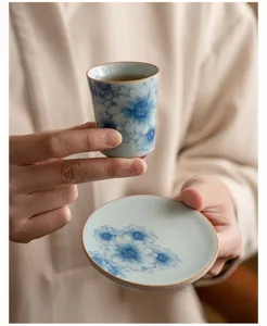 Tazza e piattino da tè in ceramica blu e bianca dettaglio con elegante design floreale.