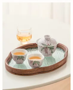 Detailed view of hand-painted wisteria ceramic gaiwan and tea cups on glass tray.