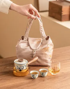 Portable kung fu tea set with side-handle teapot, two cups, fair cup, and storage bag.