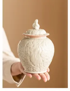 Gros plan détaillé d'un pot à thé en céramique avec motif floral en relief et couvercle.