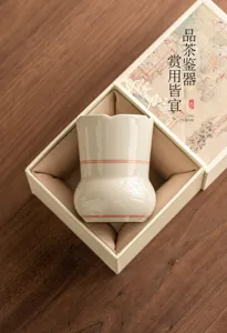 Detailansicht der handgefertigten Keramikteetasse mit roten Linien in Geschenkbox.