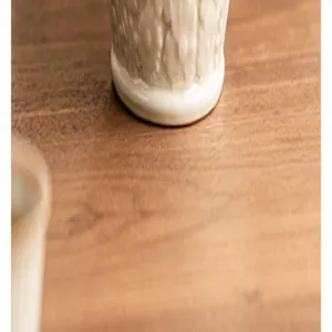 Gros plan détaillé de la base du pot à thé en céramique avec un relief floral exquis.