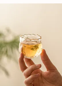 Detailed view of the exquisite heat-resistant glass tea cup with unique floral shape.