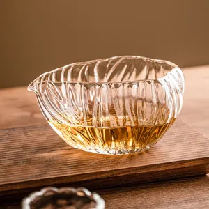 Heat-resistant glass tea pitcher fair cup with elegant fluted design for traditional tea ceremony.