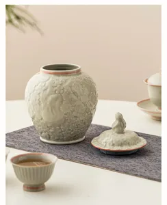 Pot à thé en céramique avec relief de lapin de lune, design élégant à double ligne.