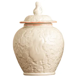Boîte à thé en céramique blanche avec couvercle lapin en relief et pot de fleurs.