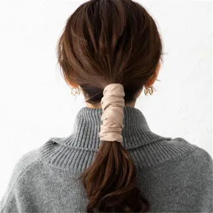 Detailopname minimalistisch effen haarlint, elegante beige wikkelstijl voor dagelijks gebruik.