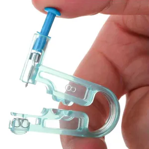 Close-up view of a disposable ear piercing tool with clear plastic body and blue press handle.