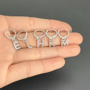 Zilveren kristallen letter creolen detailopname met alfabet hangers voor vrouwen.