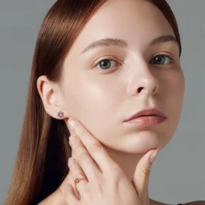 Detailed shot of model wearing multi-stone floral stud earrings and matching ring set.