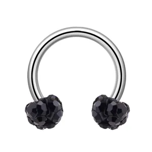 Gros plan detail de bijou de piercing corporel fer a cheval en acier inoxydable cristaux.