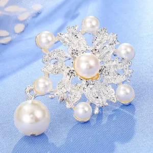 Primo piano di dettaglio di una spilla in lega argentata fiocco di neve perla strass.