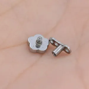Stainless steel dermal anchor body piercing detail view showing flower screw top and base.