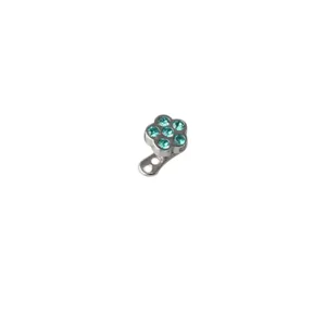 Detailed close-up of a flower-shaped dermal anchor jewelry top featuring sparkling teal gems.