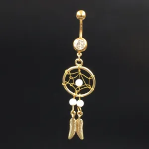 Gold tone navel ring featuring dreamcatcher design, white beads, and leaf charms for body jewelry.