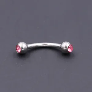 Close up view of surgical steel curved barbell eyebrow piercing ring with pink crystal gems