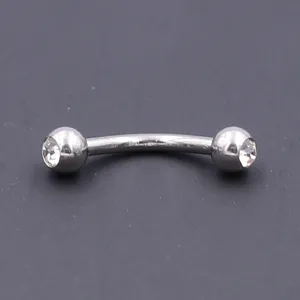 Closeup detail of stainless steel curved barbell eyebrow ring with sparkling crystal gems.