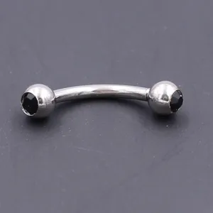 Stainless steel curved barbell eyebrow ring detail shot, dual black crystal balls piercing jewelry.