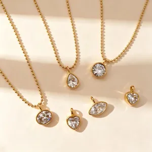 Detailaufnahme minimalistischer Goldperlenketten und austauschbarer Zirkonanhänger.