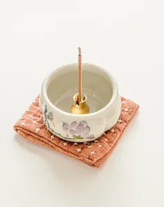 Dettaglio bruciatore di incenso in ceramica magnolia dipinto a mano, elegante motivo floreale zen.