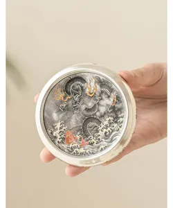 Vue rapprochée du repose-couvercle de thé en argent avec motif de dragon et de poisson chinois.
