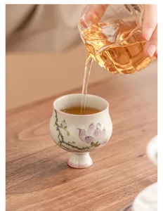 Gros plan sur le détail de la tasse à thé en céramique peinte, motif floral, glaçage lisse.