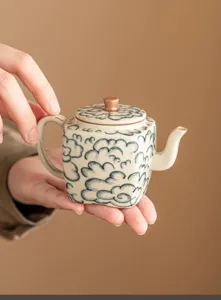 Gros plan sur les détails de la théière en céramique au motif de nuages et belle glaçure.