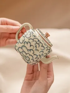 Vue rapprochée détaillée d'une théière en céramique chinoise traditionnelle avec motifs de nuages.