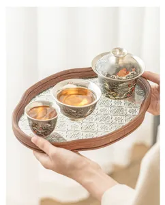 Detailed view of the silver-plated gaiwan tea set with patterned glass tray and cups.